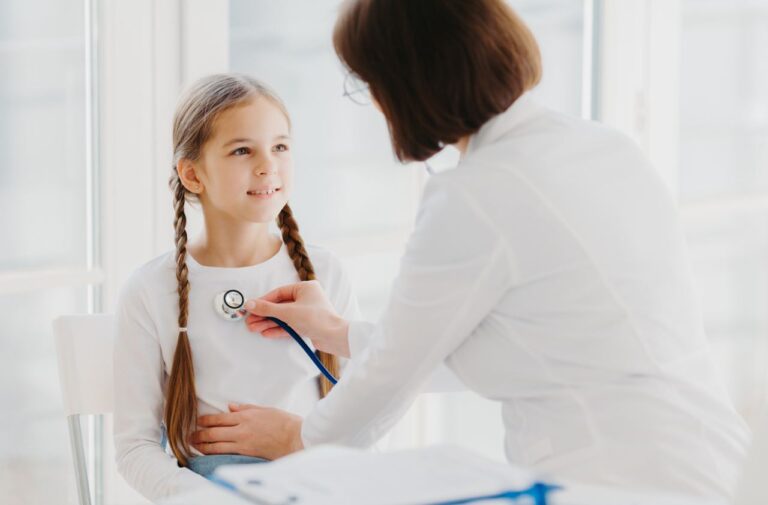 A young girl getting check by a doctor with a stethoscope